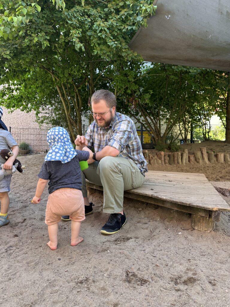 Vater mit Kind auf dem Außengelände